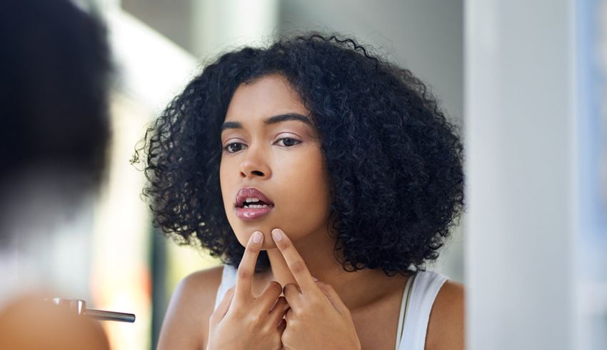 young woman determining the type of acne that is on her chin